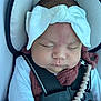 baby, infant, car_seat, headband, sleeping, strap, pacifier_clip, white_clothing, maroon_clothing, child, face, peaceful, closeup, indoors, seatbelt, cute, newborn, safety, portrait, resting
