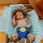 Samuel joined the competition — help win amazing prizes! baby, newborn, sleeping, crochet, cowboy_hat, boots, basket, blanket, wooden_floor, indoor, hat, cozy, cute, infant, resting, hand, face, cactus, plant, decor