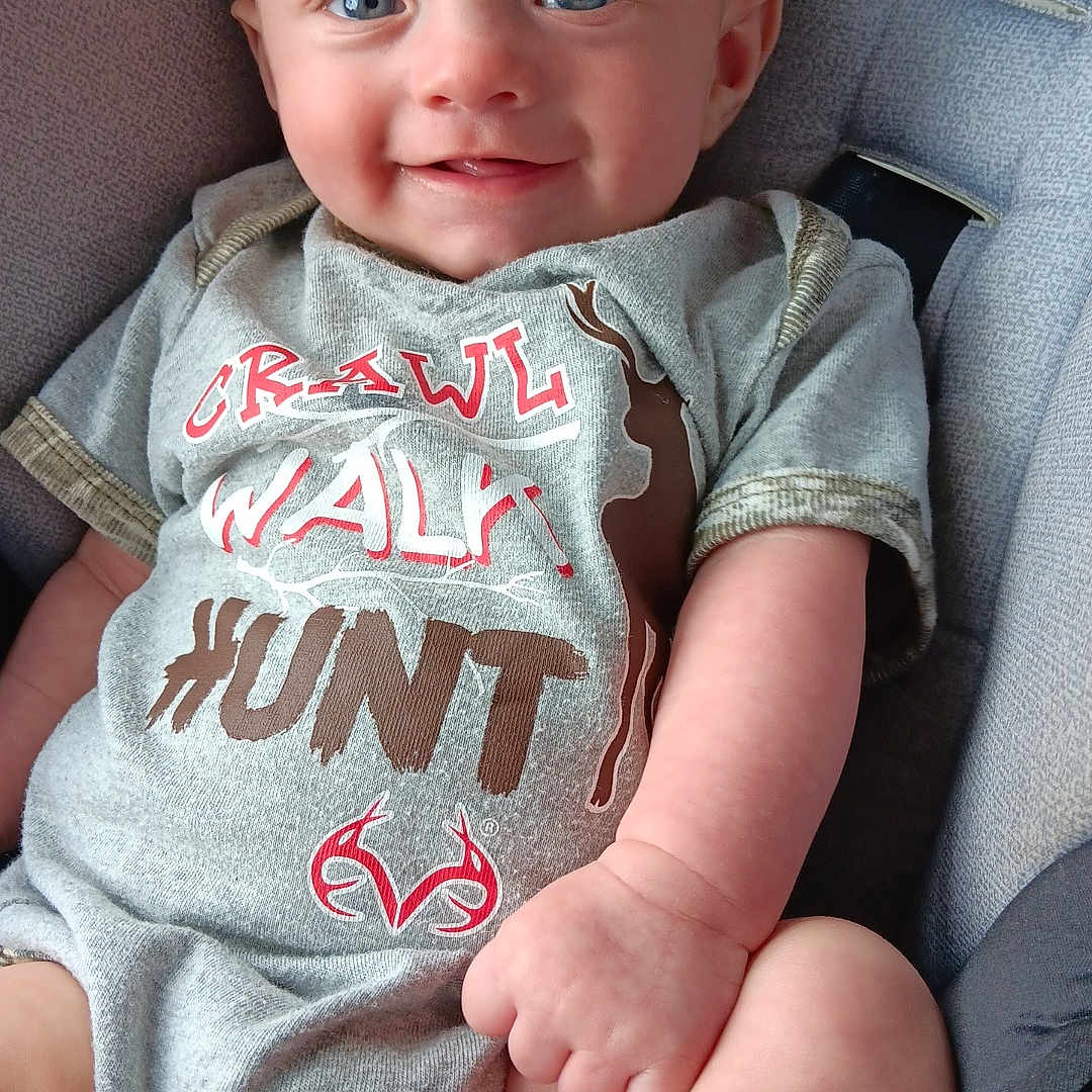 Braytyn joined the competition — help win amazing prizes! baby, baby_clothes, blue_eyes, child, closeup, cushioned_seat, cute, foot, grey_clothing, hand, happy, indoor, infant, onesie, person, portrait, sitting, skin, smiling, young_child