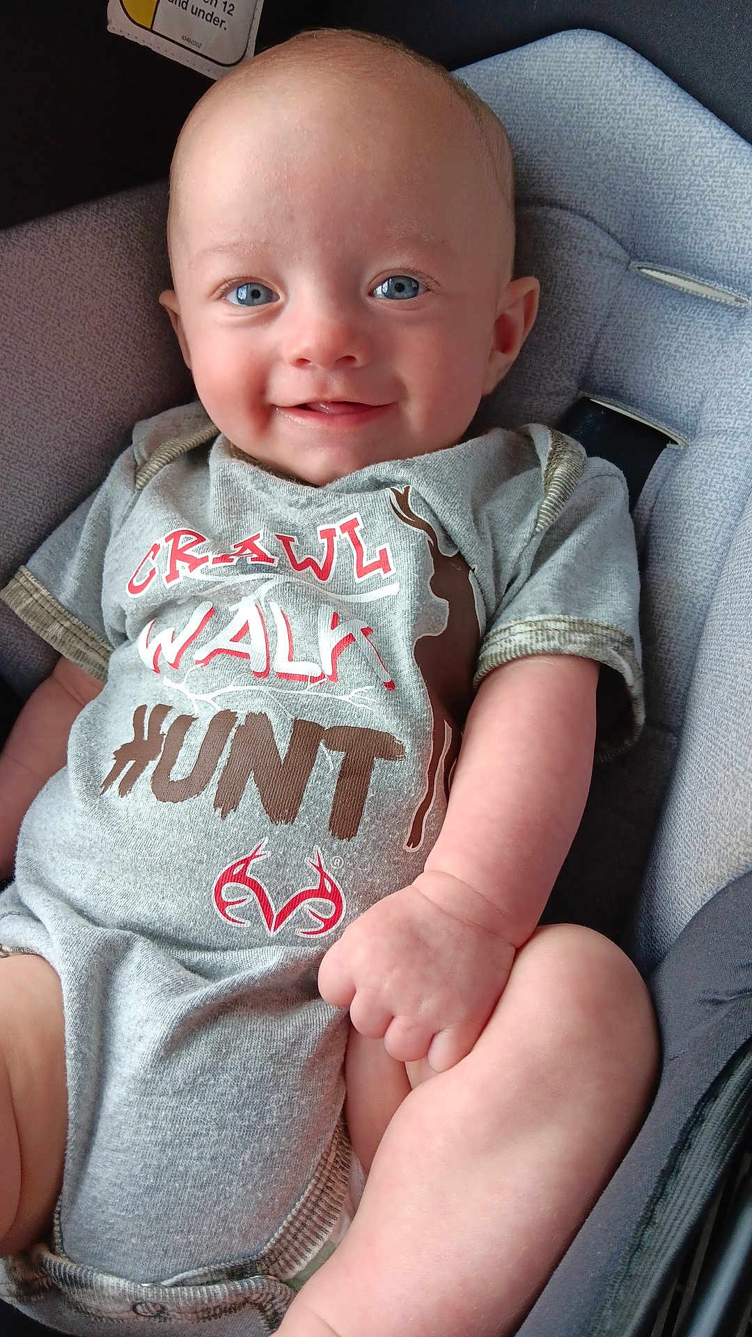 Braytyn joined the competition — help win amazing prizes! baby, smiling, blue_eyes, onesie, grey_clothing, infant, cushioned_seat, happy, child, cute, portrait, person, skin, hand, foot, indoor, closeup, baby_clothes, sitting, young_child