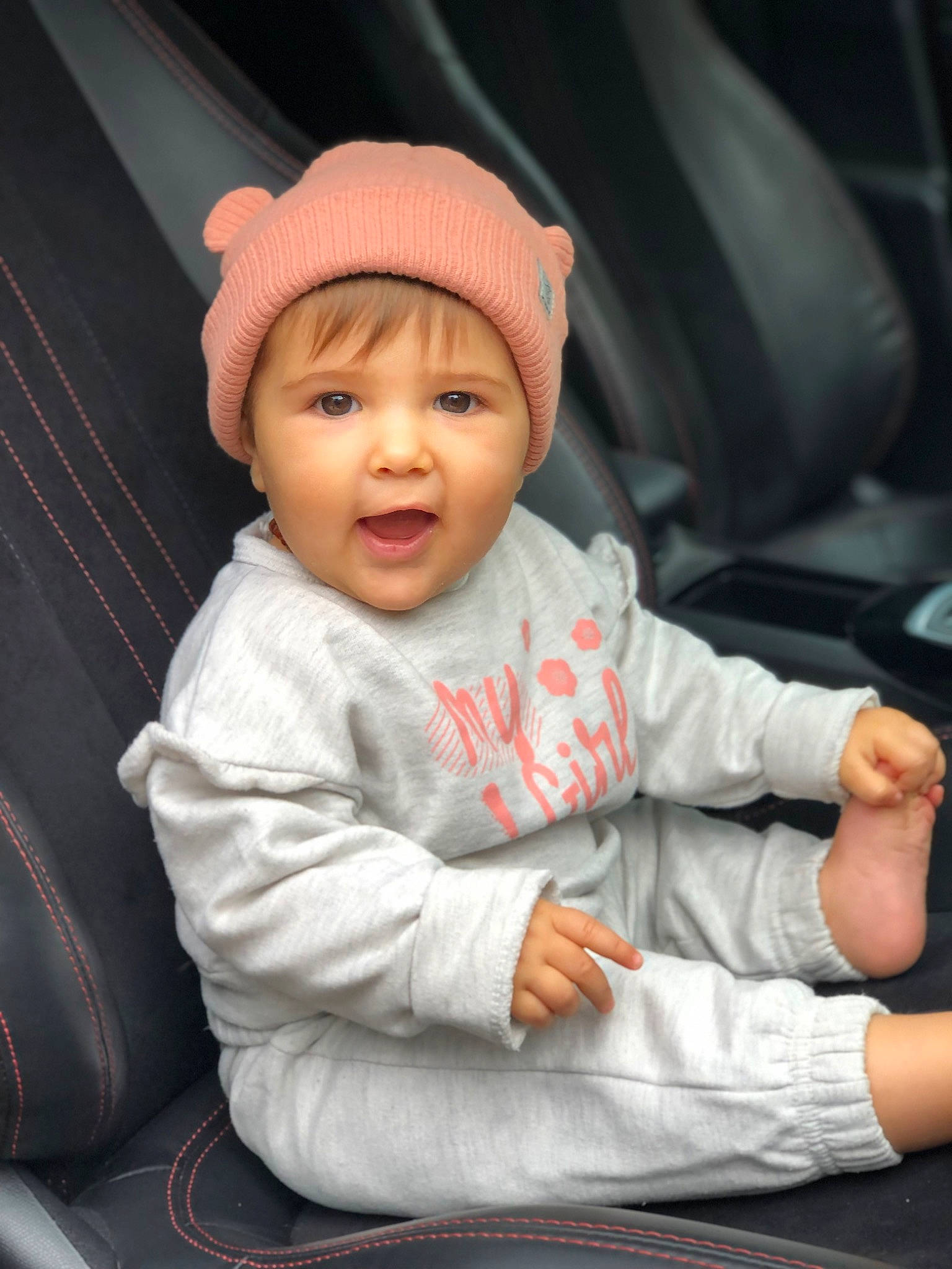 Giuseppa participe au concours pour gagner de l'argent avec cette photo : auto_part, baby, baby_products, baby_toddler_clothing, beanie, cap, car_seat, cheek, child, comfort, cool, facial_expression, family_car, fun, headwear, human, person, sitting, sleeve, smile