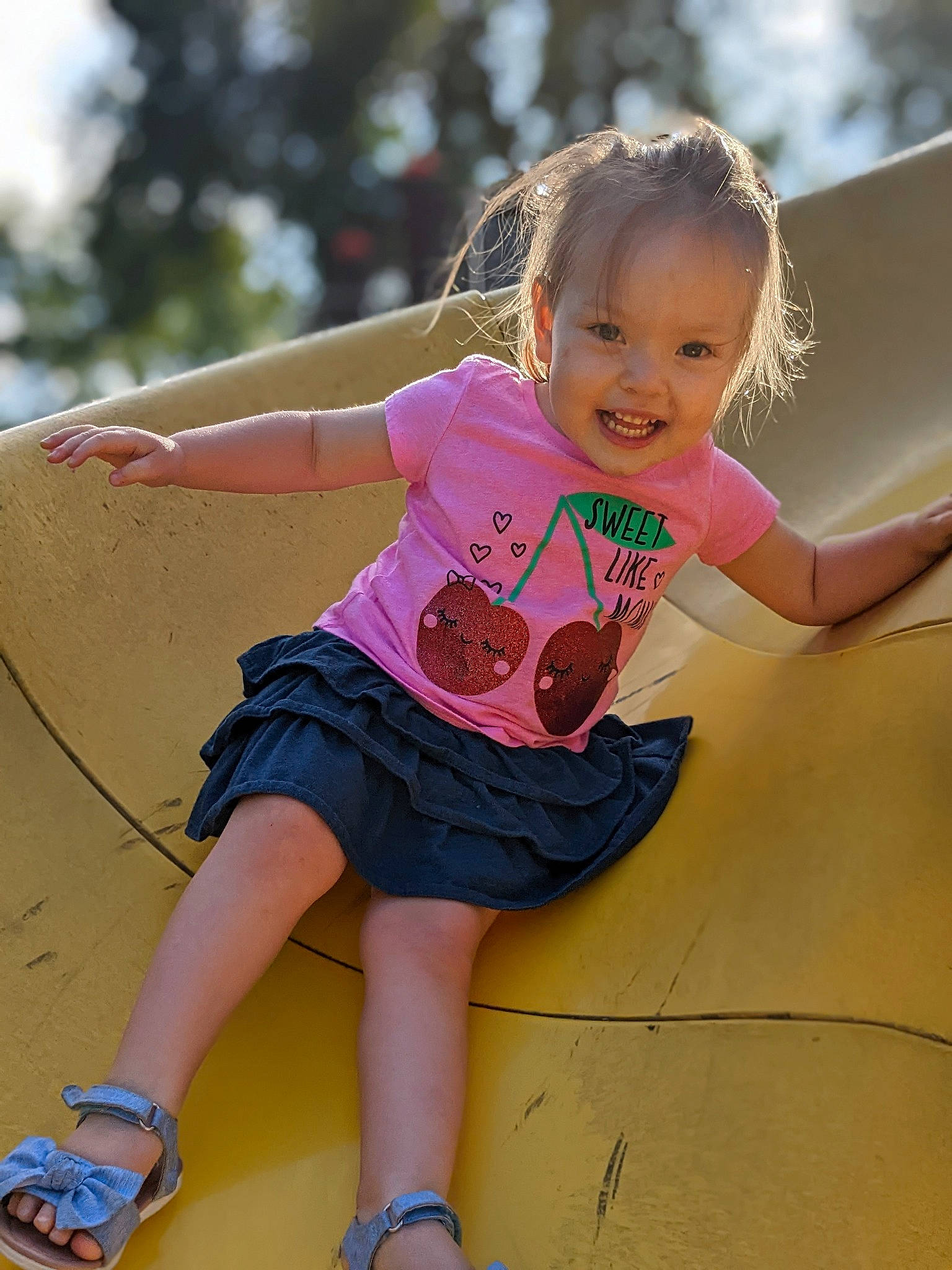 Ramona is registered to the contest to win money with this photo: baby_toddler_clothing, child, fun, grass, happy, human_leg, joy, knee, leg, leisure, magenta, person, pink, public_space, recreation, sandal, shoulder, sitting, skin, smile