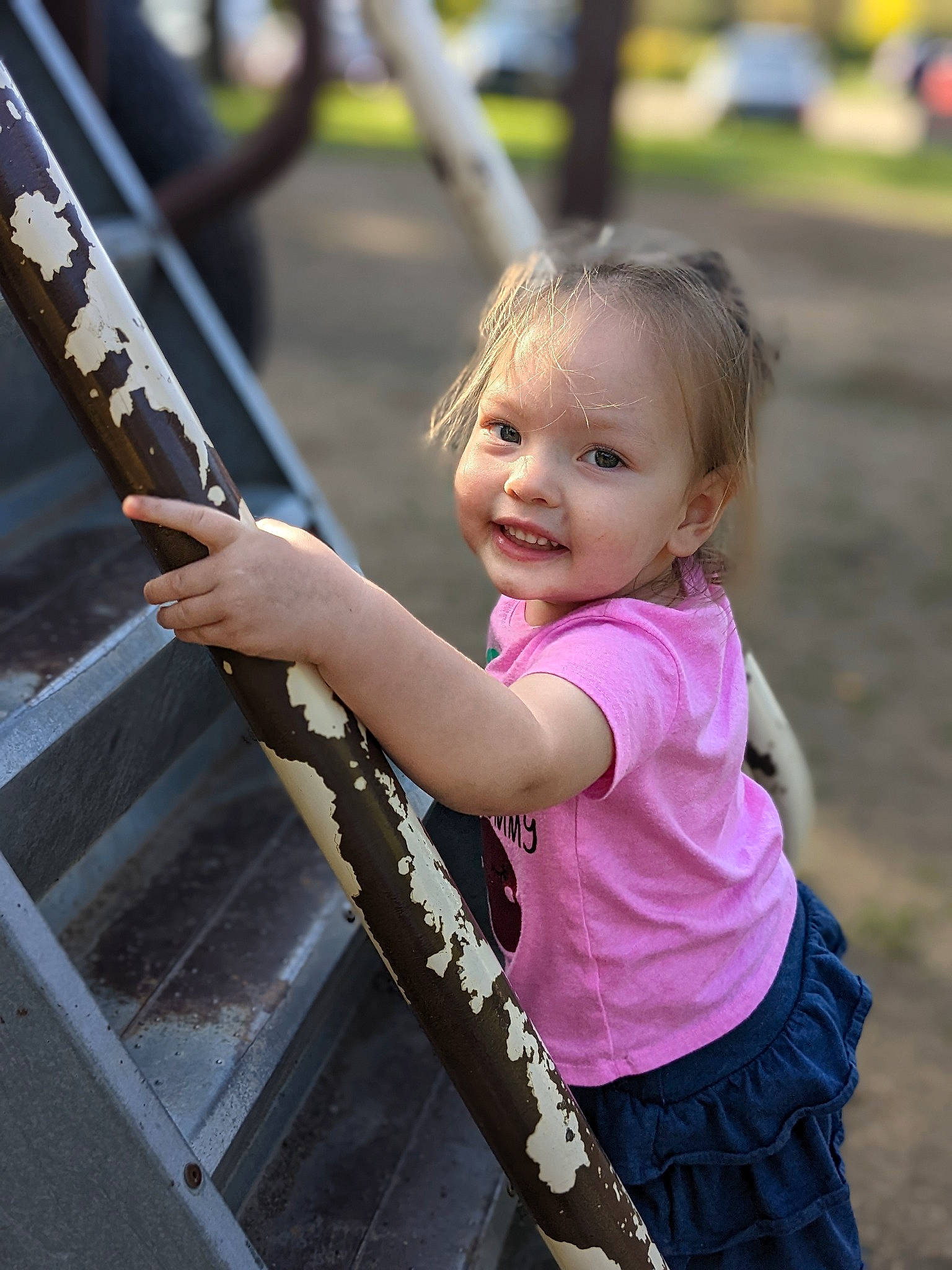 Ramona is registered to the contest to win money with this photo: blond, child, city, eye, face, fun, grass, happy, joy, leisure, magenta, outdoor_play_equipment, person, recreation, sleeve, smile, soil, t_shirt, toddler, tree