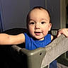 toddler, child, blue_shirt, playpen, indoor, curious, face, arm, expression, person, baby, furniture, home, lighting, portrait, young_child, smile, skin, hair, room