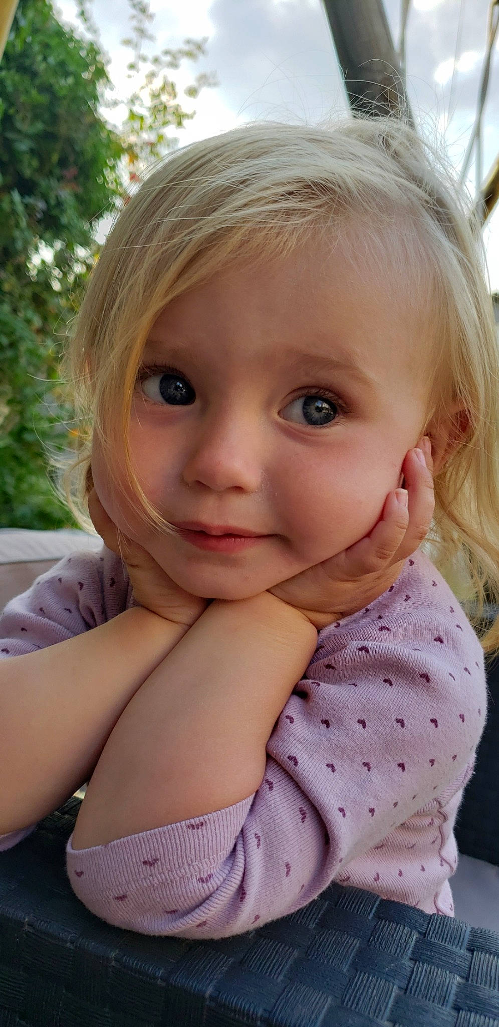 Analya participe au concours pour gagner de l'argent avec cette photo : baby_toddler_clothing, bangs, blond, cheek, chin, close_up, eye, eyebrow, eyelash, gesture, grass, happy, iris, lip, mouth, nose, person, pink, plant, skin