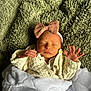 baby, newborn, sleeping, blanket, headband, bow, knitted_sweater, cozy, soft_texture, green_blanket, white_blanket, infant, peaceful, cute, portrait, hands, face, indoors, resting, child