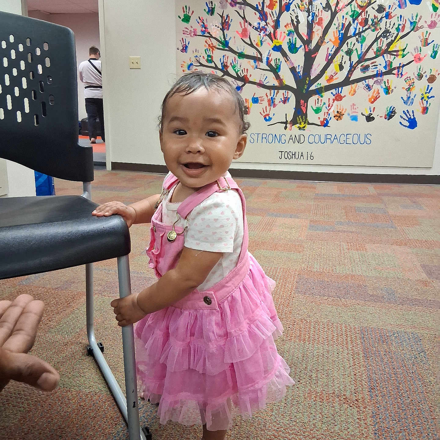 Xochitl Iv is registered to the contest to win money with this photo: baby, barefoot, carpet, chair, child, colorful, cute, decor, hand, handprint_mural, happy, indoor, person, pink_dress, portrait, smiling, standing, toddler, wall_art, young_child