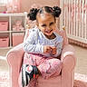 child, girl, smiling, pigtails, pink, armchair, nursery, crib, plush_toy, carpet, sneakers, clothing, room, wall_art, curtains, furniture, happy, indoor, person, portrait