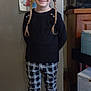 child, smiling, braids, black_top, checkered_pants, shiny_shoes, indoor, kitchen, refrigerator, drawing, cartoon, floor_tiles, cabinet, standing, happy, person, hair_ties, illustration, home, cute
