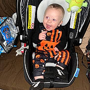 Wyatt joined the competition — help win amazing prizes! baby, black_and_orange, car_seat, child, clothing, cute, face, footwear, frog_toy, halloween_outfit, happy, indoor, infant, person, plush_toy, pumpkin_pattern, seat, sitting, smiling, snack_bag