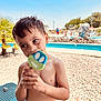 Ashtyn joined the competition — help win amazing prizes! child, boy, popsicle, smile, summer, pool, outdoor, sunny, blue_sky, water, bench, palm_tree, rocks, swimwear, happy, food, playful, vacation, recreation, portrait