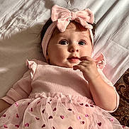 Maria Seraya is registered to the contest to win money with this photo: baby, child, infant, pink, headband, bow, dress, tulle, hearts, bed, blanket, hand, face, eyes, cute, portrait, indoors, soft_lighting, lying_down, person