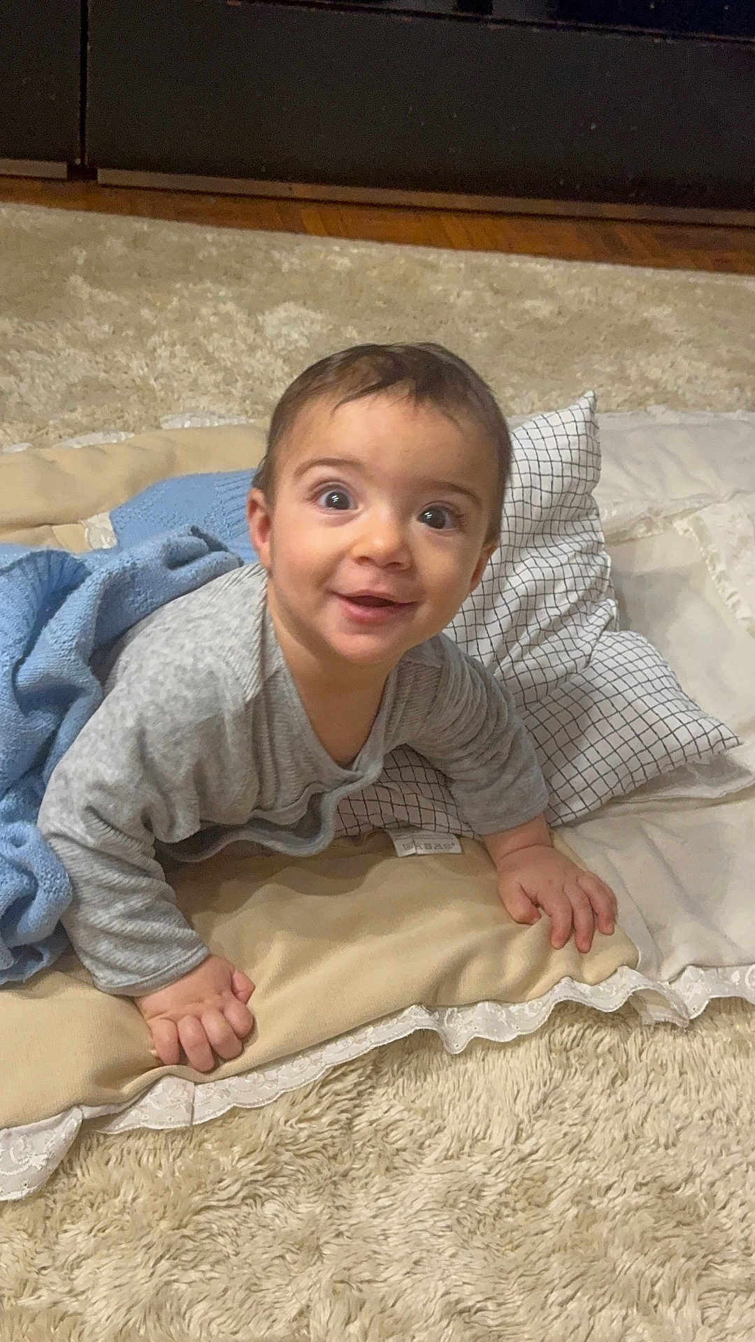 Saif participe au concours pour gagner de l'argent avec cette photo : baby, blanket, carpet, child, clothing, cozy, cute, expression, face, floor, hands, happy, home, indoors, infant, person, pillow, portrait, smiling, young