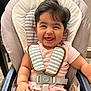 baby, smiling, high_chair, child, pink_clothing, harness, indoor, happy, cute, seatbelt, infant, person, young_child, face, hair, chubby, sitting, arm, safety, seat