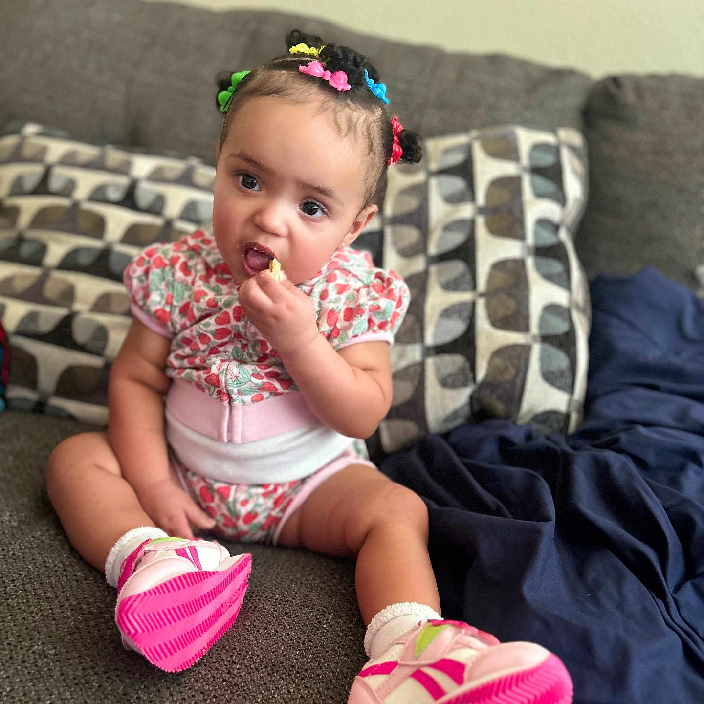 Majesty joined the competition — help win amazing prizes! baby, blanket, casual, child, colorful_accessories, couch, curious_expression, cushions, footwear, hair_clips, home, indoor, patterned_clothing, person, pink_shoes, sitting, snack, sofa, toddler, young_child