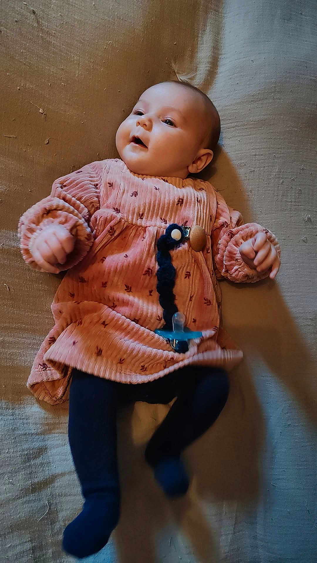 Cléo joined the competition — help win amazing prizes! baby, infant, pink_dress, pacifier, lying_down, blanket, navy_tights, cute, child, young, indoors, portrait, soft_lighting, clothing, hands, feet, face, expression, baby_accessory, relaxed