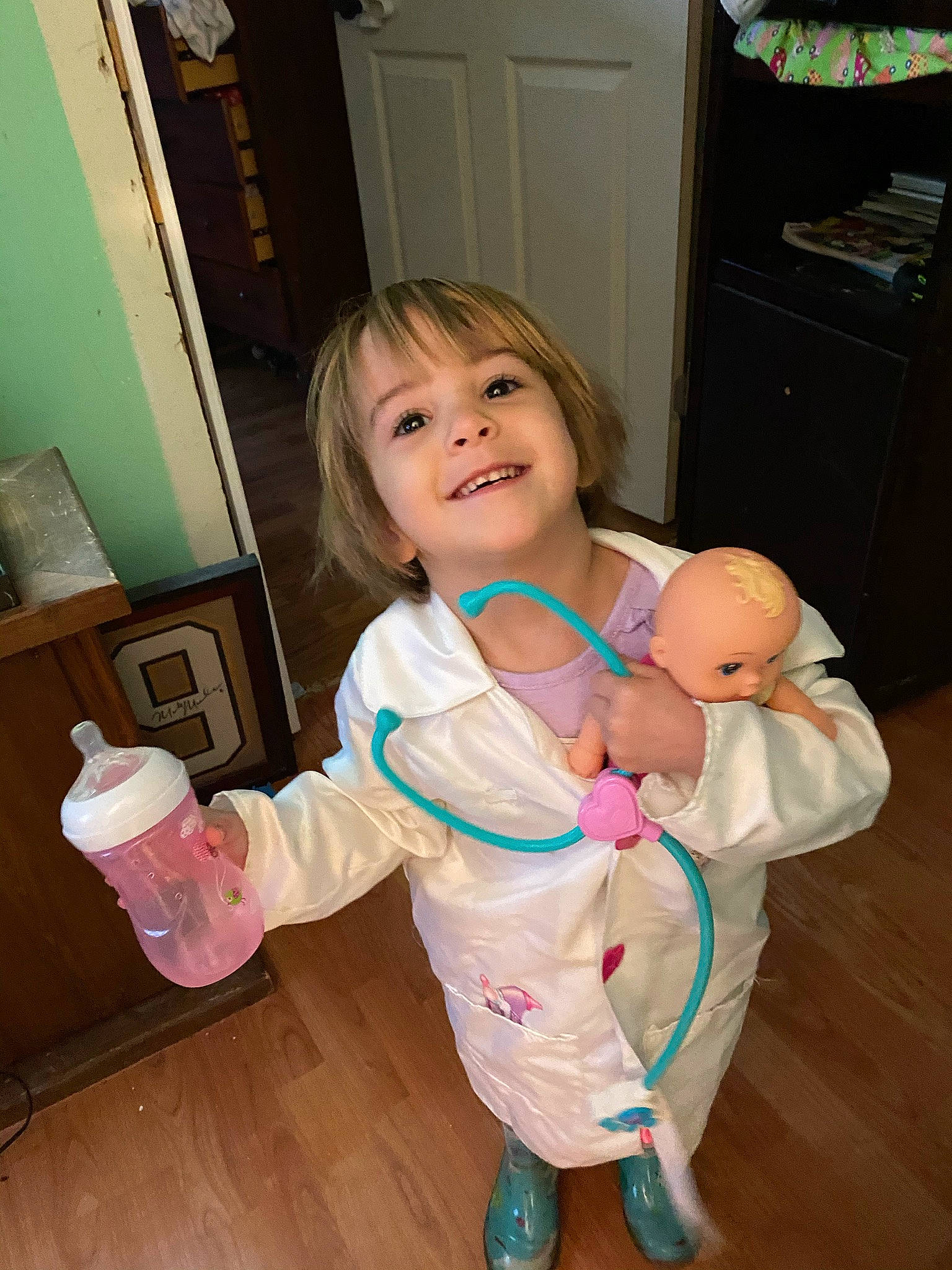 River is registered to the contest to win money with this photo: abdomen, baby, baby_products, baby_toddler_clothing, blond, bottle, cabinetry, child, cupboard, door, home_door, joy, lamp, nightwear, person, plastic, plastic_bottle, refrigerator, sock, stomach