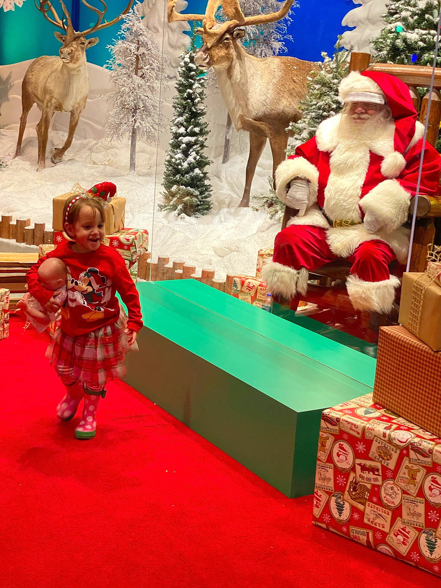 River is registered to the contest to win money with this photo: adaptation, carpet, christmas, christmas_decoration, christmas_eve, christmas_ornament, christmas_tree, deer, event, fawn, fictional_character, fur, headwear, holiday, interior_design, joy, organism, ornament, person, toy