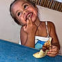child, girl, smiling, chocolate, food, snack, table, blue_table, happy, messy_face, finger, brown_hair, necklace, white_background, bamboo, sitting, casual, eating, indoors, playful