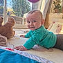 baby, blue_sweater, child, crawling, curtain, floor, happy, home, indoor, nursery, plant, playmat, portrait, potted_plant, smiling, sunlight, teddy_bear, toy, tummy_time, window