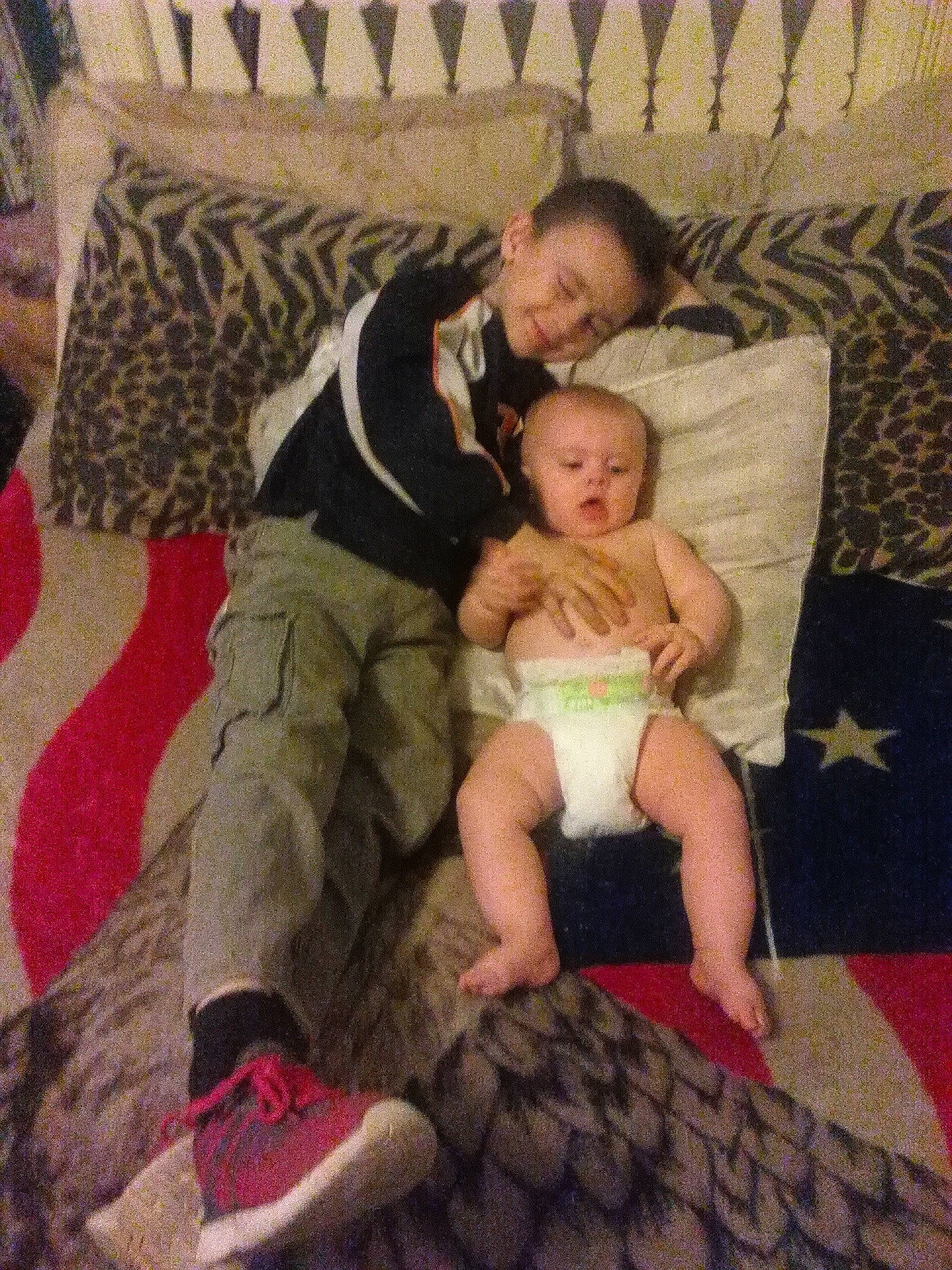 Gabriel is registered to the contest to win money with this photo: baby, child, comfort, couch, flooring, foot, fun, happy, human_leg, interaction, joy, lap, leg, linens, living_room, person, room, sitting, sock, thigh