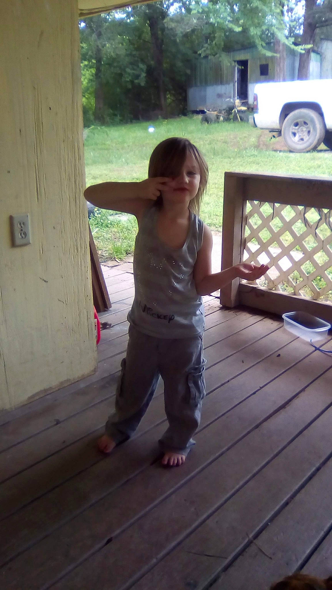 Alayna is registered to the contest to win money with this photo: child, deck, floor, flooring, hardwood, house, leisure, person, plant, porch, shorts, sitting, t_shirt, tire, toddler, tree, truck, wheel, wood, wood_flooring