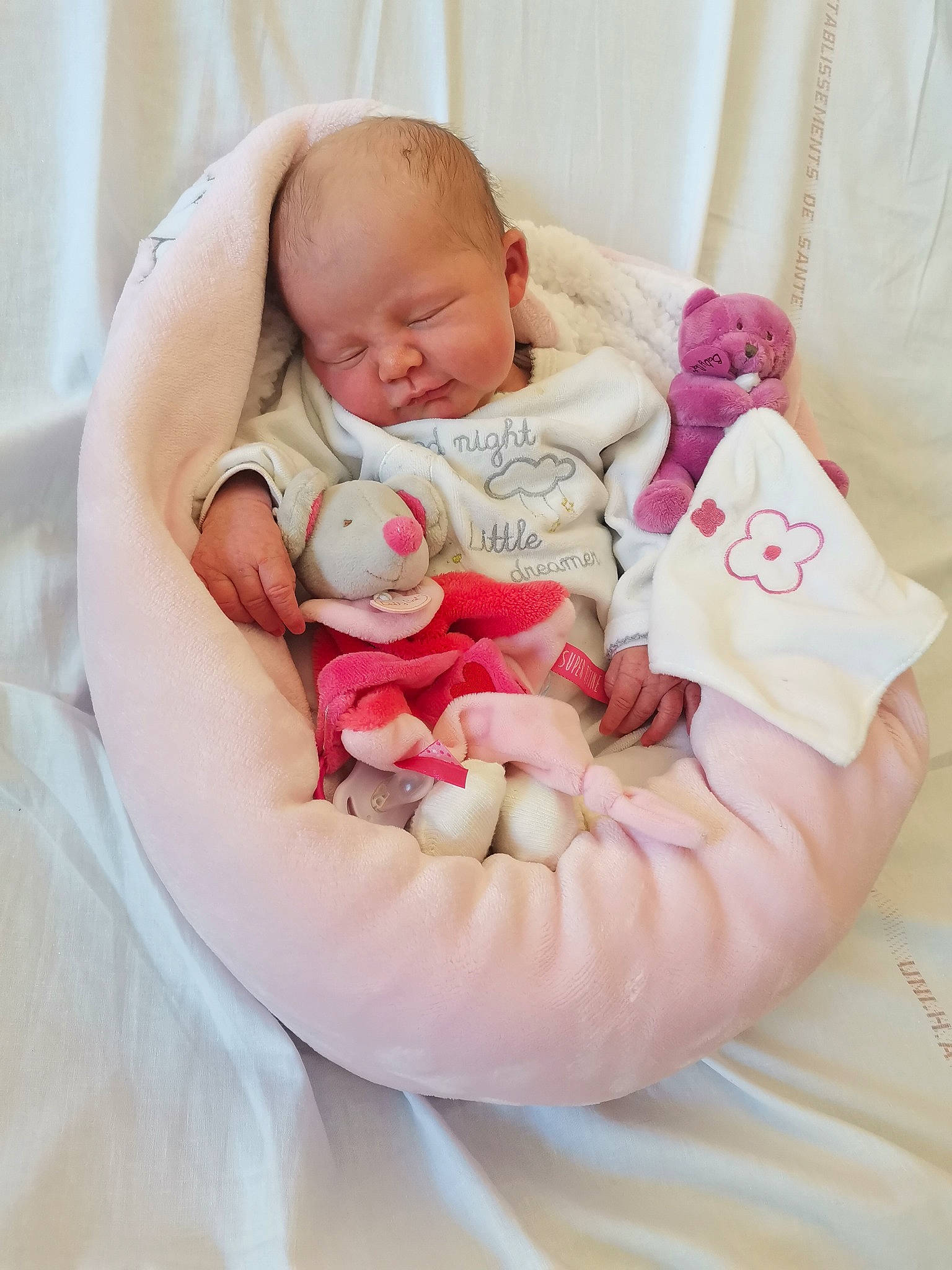 Angèle a rejoint le concours — aidez-le/la à gagner de superbes lots ! arm, baby, baby_products, baby_sleeping, baby_toddler_clothing, bed, bedtime, cheek, comfort, face, finger, head, human_body, leg, linens, mouth, person, pink, skin, textile