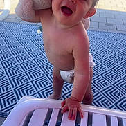 Maylon a rejoint le concours — aidez-le/la à gagner de superbes lots ! toddler, child, plush_toy, elephant_toy, diaper, outdoor, rug, lounge_chair, hand, face, smile, happy, sunlight, shadow, paving_stones, bare_chest, young_child, toy, patterned_rug, patio