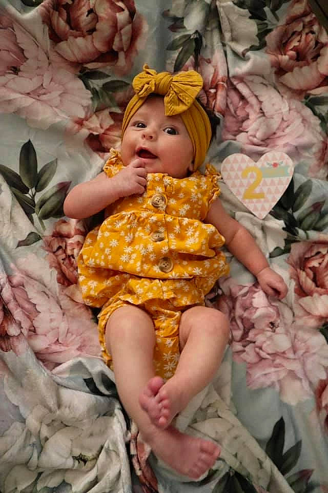 Salem is registered to the contest to win money with this photo: baby_toddler_clothing, cheek, child, day_dress, doll, dress, fashion_design, happy, head, headwear, leaf, organ, pattern, peach, person, pink, ruffle, skin, textile, toddler