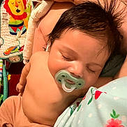 Niko is registered to the contest to win money with this photo: baby, sleeping, pacifier, tattoo, arm, blanket, baby_gear, child, infant, resting, comfort, clothing, person, indoor, closeup, peaceful, hair, skin, hand, adult