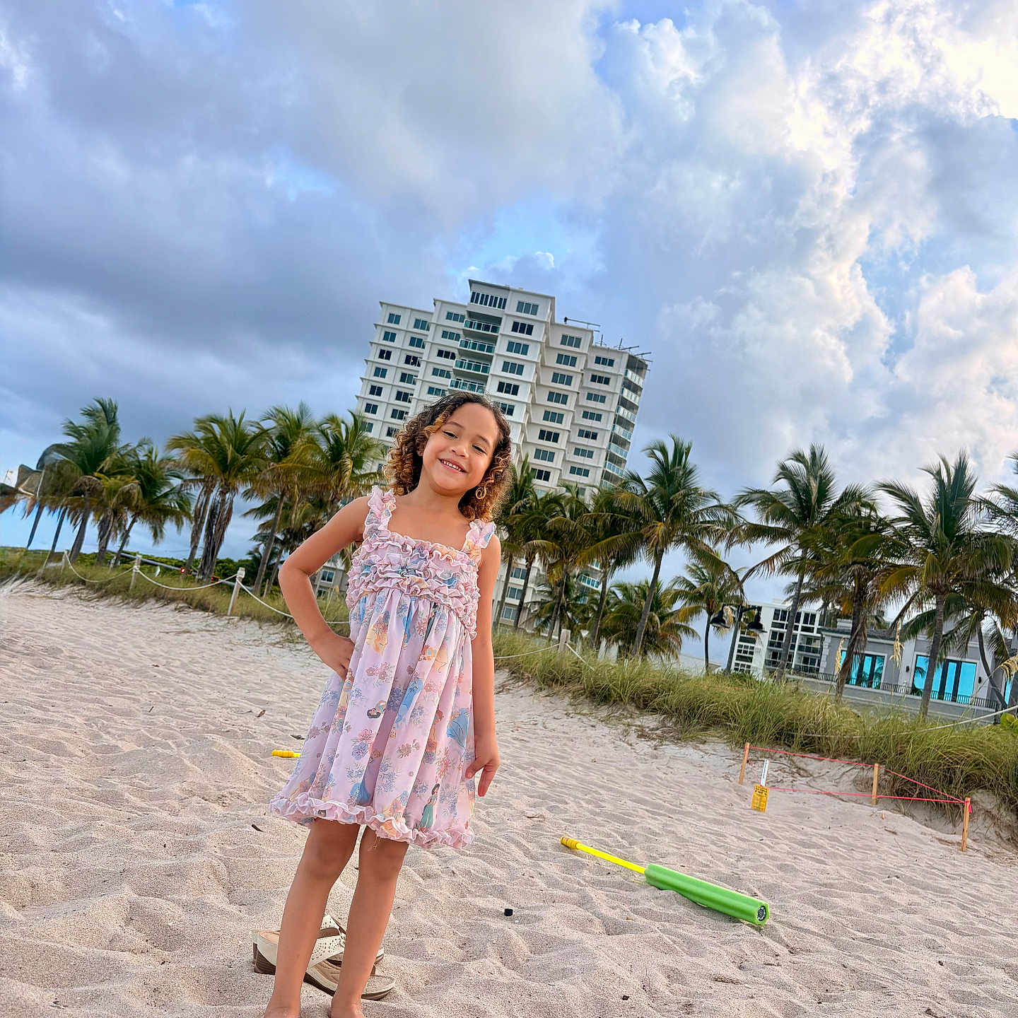 Noha joined the competition — help win amazing prizes! child, girl, beach, sand, dress, smile, palm_trees, building, clouds, sky, toy, barefoot, outdoor, sunset, nature, vacation, holiday, summer, play, portrait