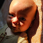 Sohan participe au concours pour gagner de l'argent avec cette photo : baby, infant, face, portrait, closeup, child, sunlight, shadow, skin, texture, clothing, fabric, pattern, warm_light, expression, cute, head, eyes, newborn, soft