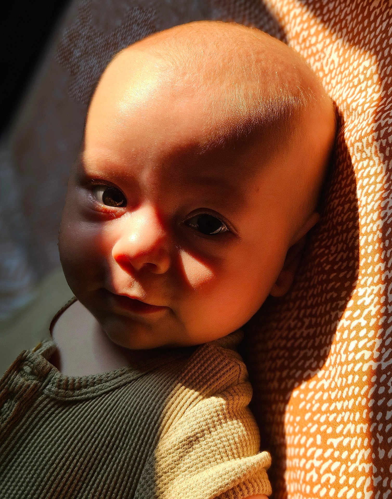 Sohan participe au concours pour gagner de l'argent avec cette photo : baby, infant, face, portrait, closeup, child, sunlight, shadow, skin, texture, clothing, fabric, pattern, warm_light, expression, cute, head, eyes, newborn, soft