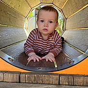 Cristian a rejoint le concours — aidez-le/la à gagner de superbes lots ! baby, child, striped_shirt, wood, playground, tunnel, crawling, outdoor, daylight, curious, face, hands, wooden_tunnel, natural_light, young_child, person, play, cute, expression, casual_clothing
