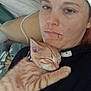 animal, blanket, casual, cat, closeup, comfort, cozy, cuddling, face, indoor, kitten, orange_tabby, person, pet, piercing, pillow, relaxation, resting, sleeping, young_adult