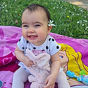 Sheïna a rejoint le concours — aidez-le/la à gagner de superbes lots ! baby, blanket, child, cute, doll, flower, grass, happy, nature, outdoor, park, pink, playtime, portrait, sitting, smiling, sunlight, tights, toddler, toy