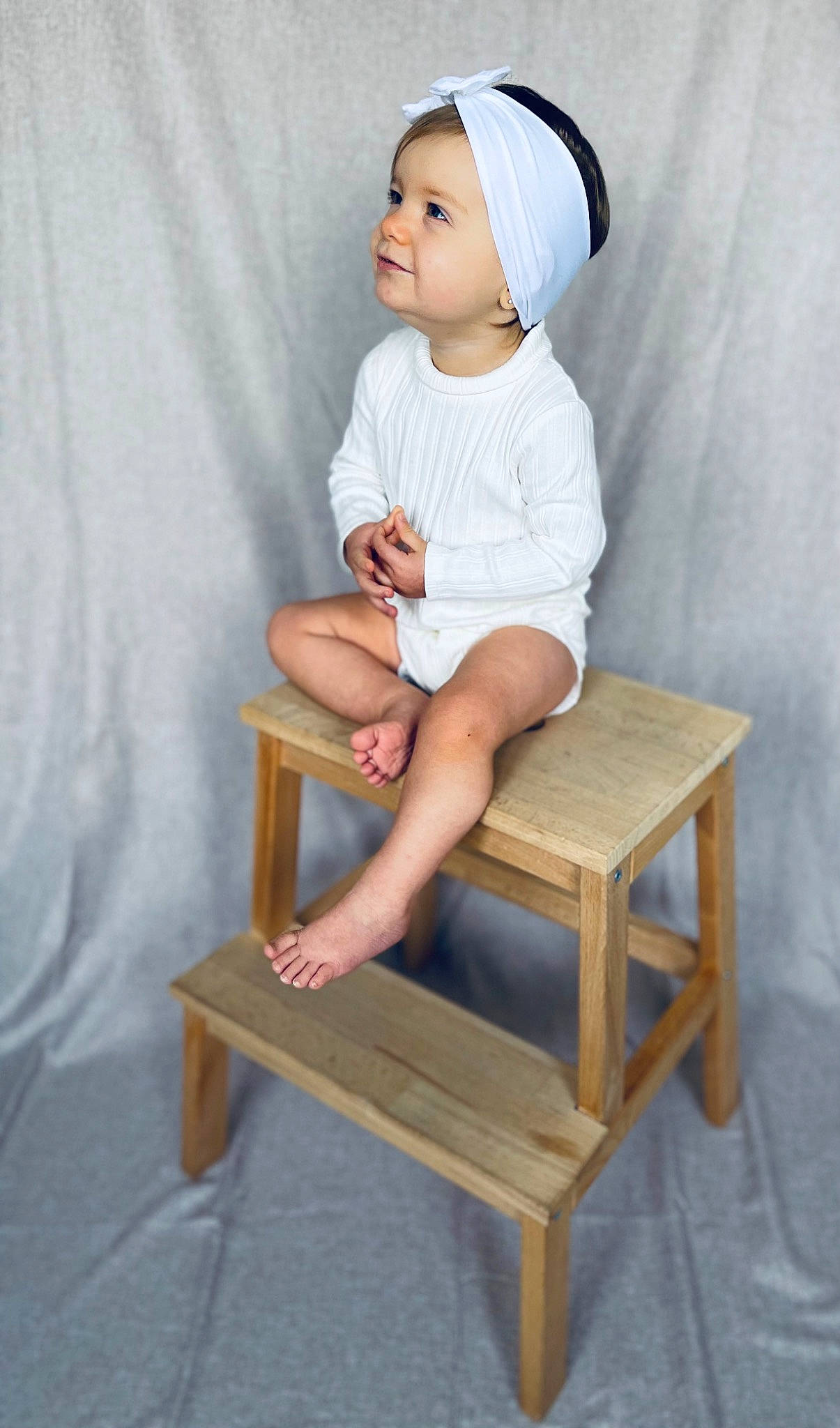 Iris participe au concours pour gagner de l'argent avec cette photo : baby, baby_toddler_clothing, cap, chair, child, comfort, dress, face, furniture, head, headwear, human_body, human_leg, knee, leg, person, room, shorts, sitting, sleeve
