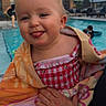 baby, building, child, expression, face, fun, hand, outdoor, person, playful, pool, railing, skin, smiling, summer, swimsuit, tongue_out, towel, water, window