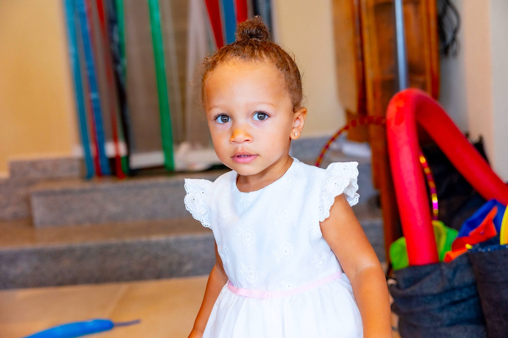 Stormi joined the competition — help win amazing prizes! baby, baby_toddler_clothing, blue, child, dress, event, facial_expression, flooring, fun, happy, leisure, one_piece_garment, person, room, sitting, smile, standing, t_shirt, toddler, vacation