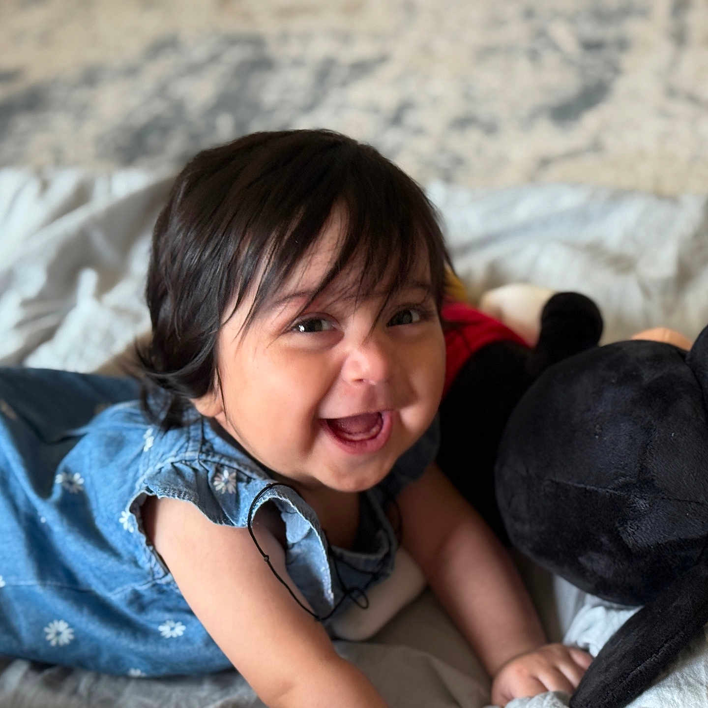 Raaha is registered to the contest to win money with this photo: baby, bed, blue_outfit, child, clothing, crawling, cute, happy, head, indoor, infant, mickey_mouse, person, playful, plush_toy, portrait, smiling, soft_toy, toddler, young_child