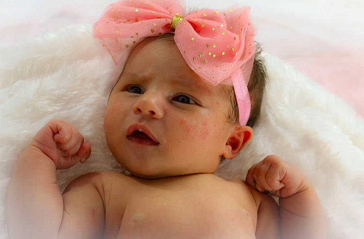 Kaiah is registered to the contest to win money with this photo: baby, cheek, child, close_up, eye, face, fashion_accessory, fur, hair_accessory, hand, head, headgear, lip, mouth, nose, person, photography, pink, portrait_photography, skin