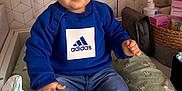 Thomas a rejoint le concours — aidez-le/la à gagner de superbes lots ! toddler, child, baby, blue_sweatshirt, adidas, diaper, changing_pad, bunny_pattern, shoes, jeans, indoor, nursery, baby_care, basket, skin, face, hand, expression, clothing, person