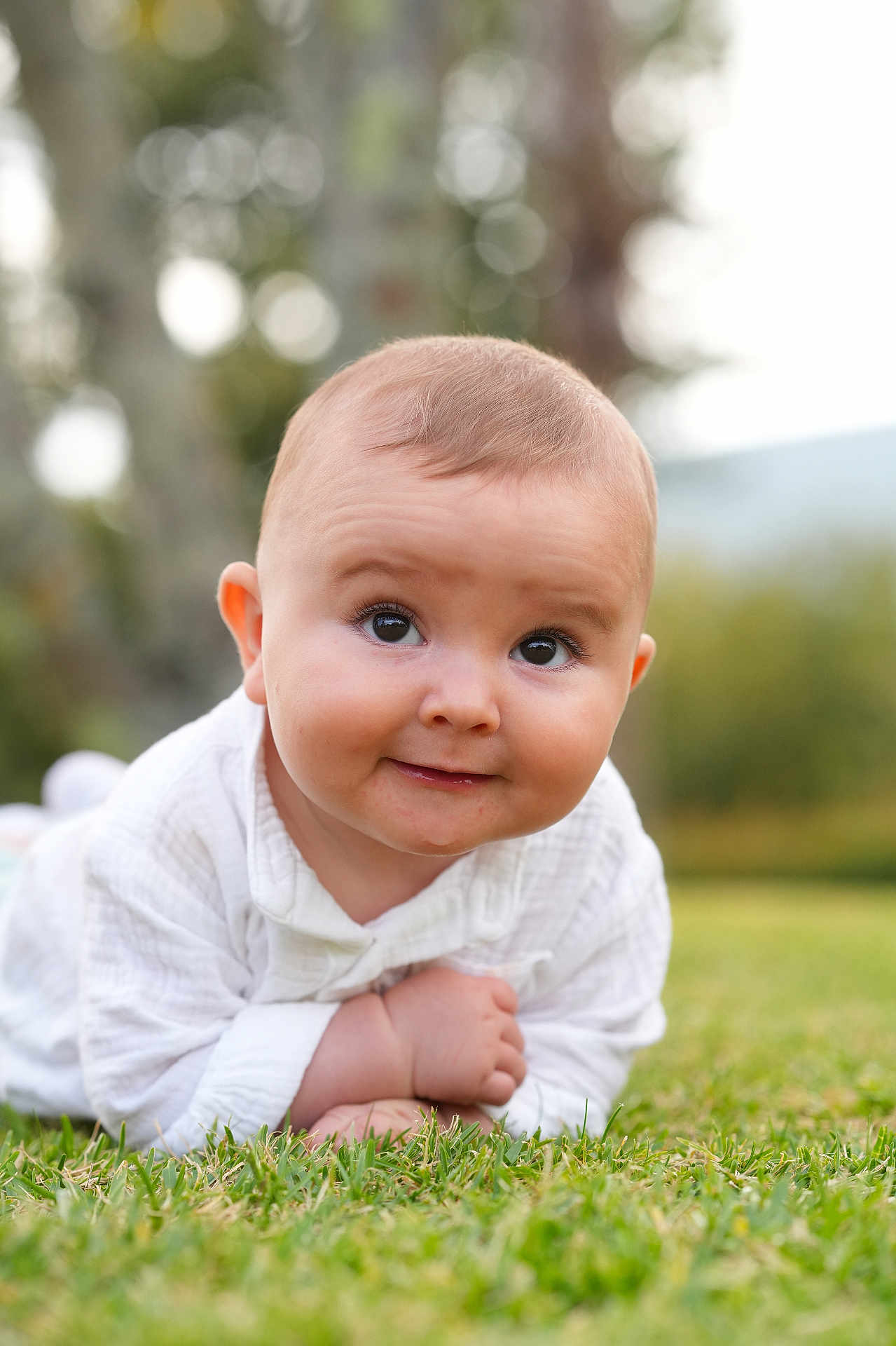 Mathias participe au concours pour gagner de l'argent avec cette photo : baby, child, infant, grass, outdoor, smile, face, cute, white_clothing, portrait, nature, greenery, happy, toddler, young, lying_down, expression, skin, head, eyes