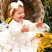 Kelsy a rejoint le concours — aidez-le/la à gagner de superbes lots ! baby, child, smiling, white_dress, headband, sunflowers, basket, blanket, outdoor, grass, nature, happy, cute, portrait, sitting, flower, infant, warm, daylight, pretty