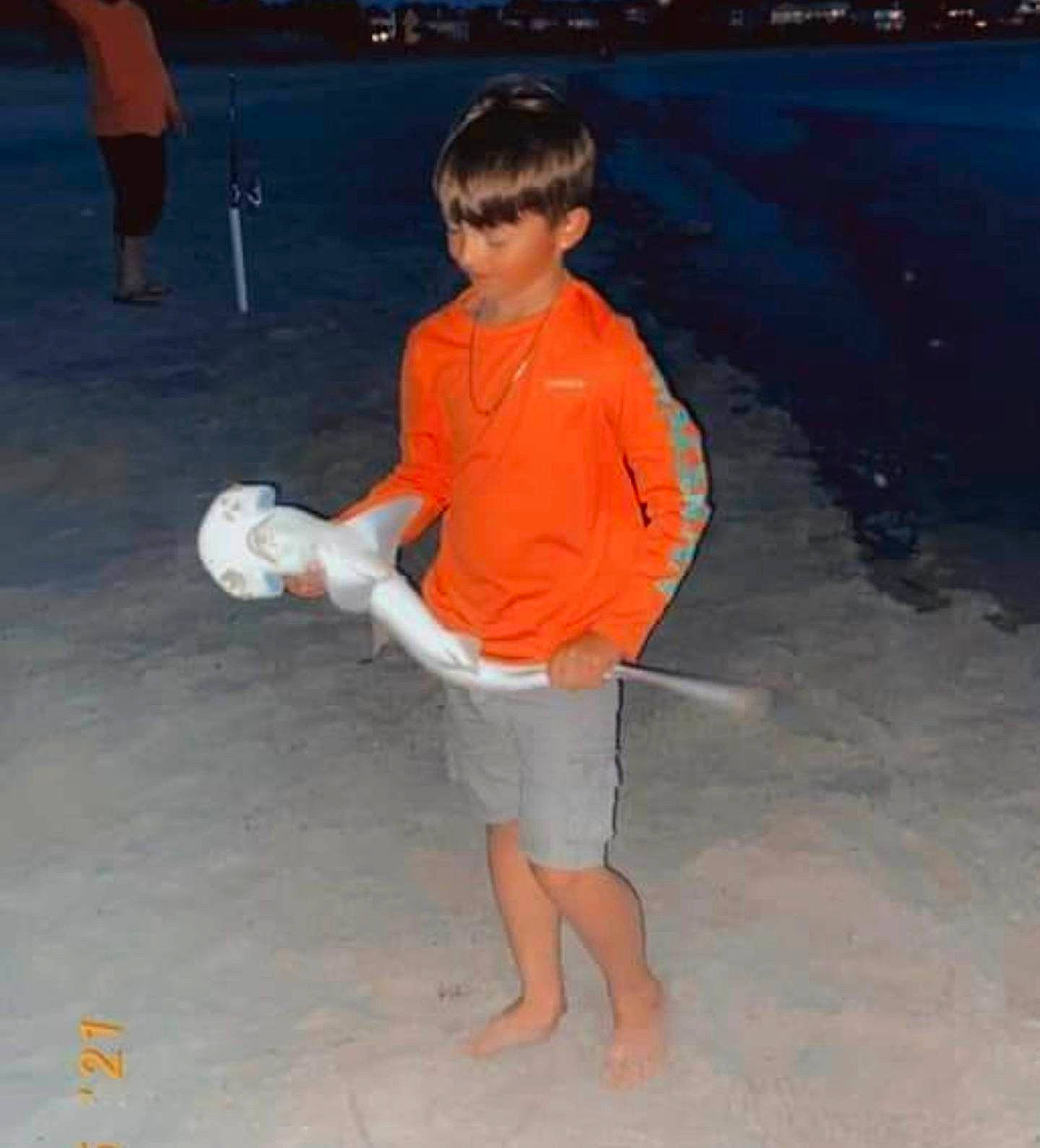 Tray is registered to the contest to win money with this photo: ball, barefoot, beach, bermuda_shorts, board_short, child, electric_blue, foot, fun, happy, human_leg, leisure, ocean, person, recreation, sand, shorts, sleeve, t_shirt, thigh