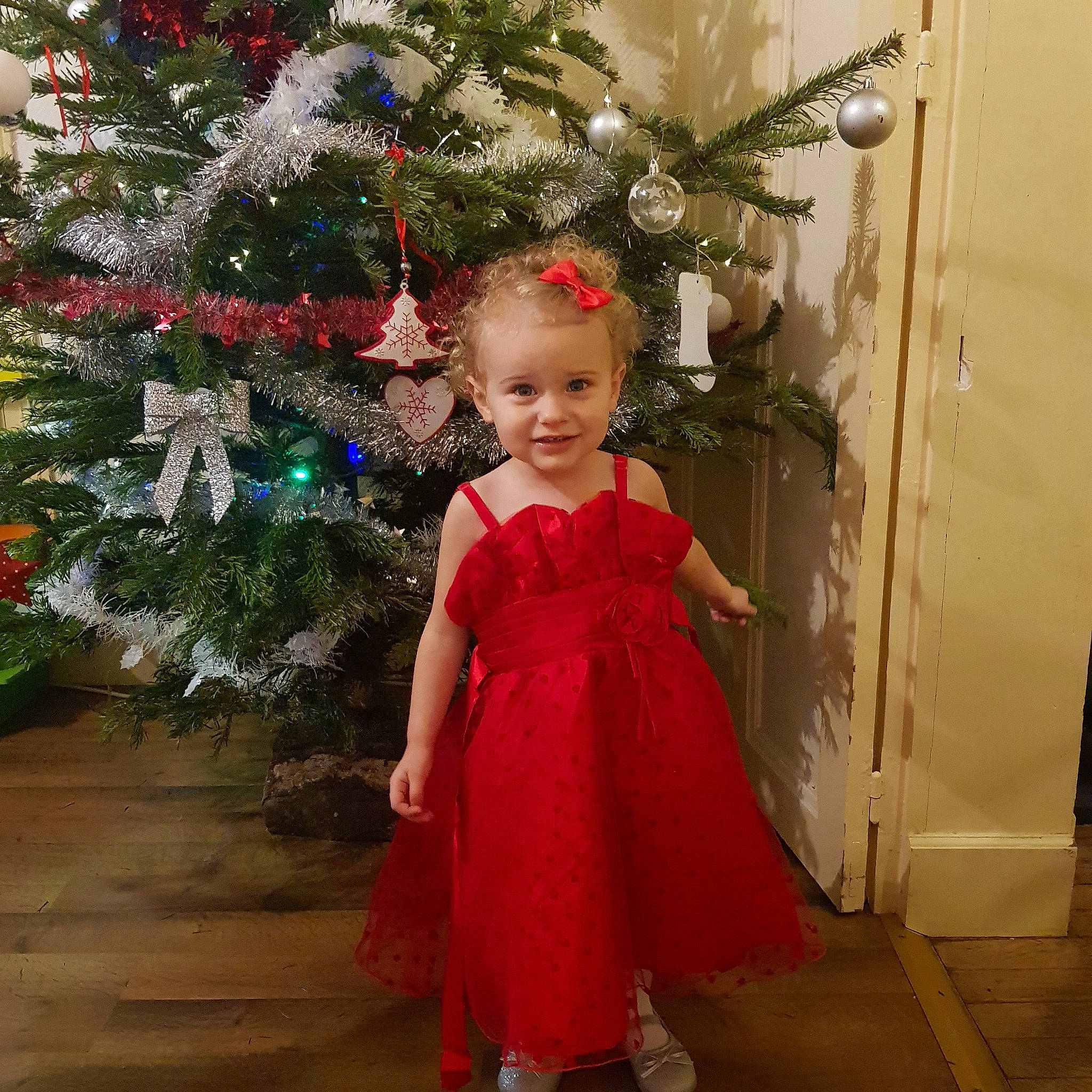 Mïa a rejoint le concours — aidez-le/la à gagner de superbes lots ! bridal_party_dress, child, christmas, christmas_decoration, christmas_eve, christmas_ornament, christmas_tree, clothing, dress, event, fir, formal_wear, gown, holiday, interior_design, joy, person, plant, smile, standing