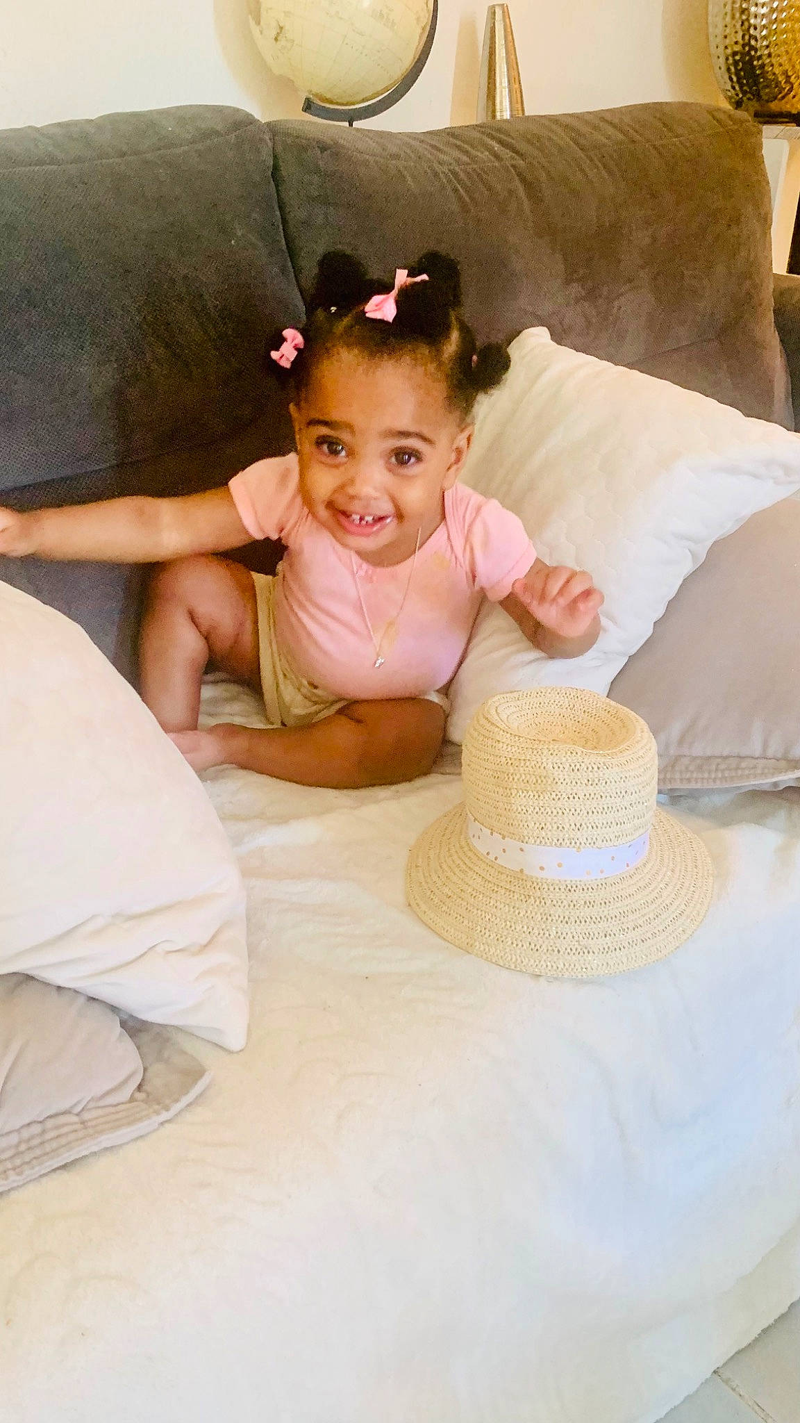 Trinity participe au concours pour gagner de l'argent avec cette photo : baby, baby_toddler_clothing, child, comfort, couch, fashion_accessory, flooring, furniture, happy, hat, joy, leisure, linens, person, pillow, sitting, smile, sun_hat, table, tableware