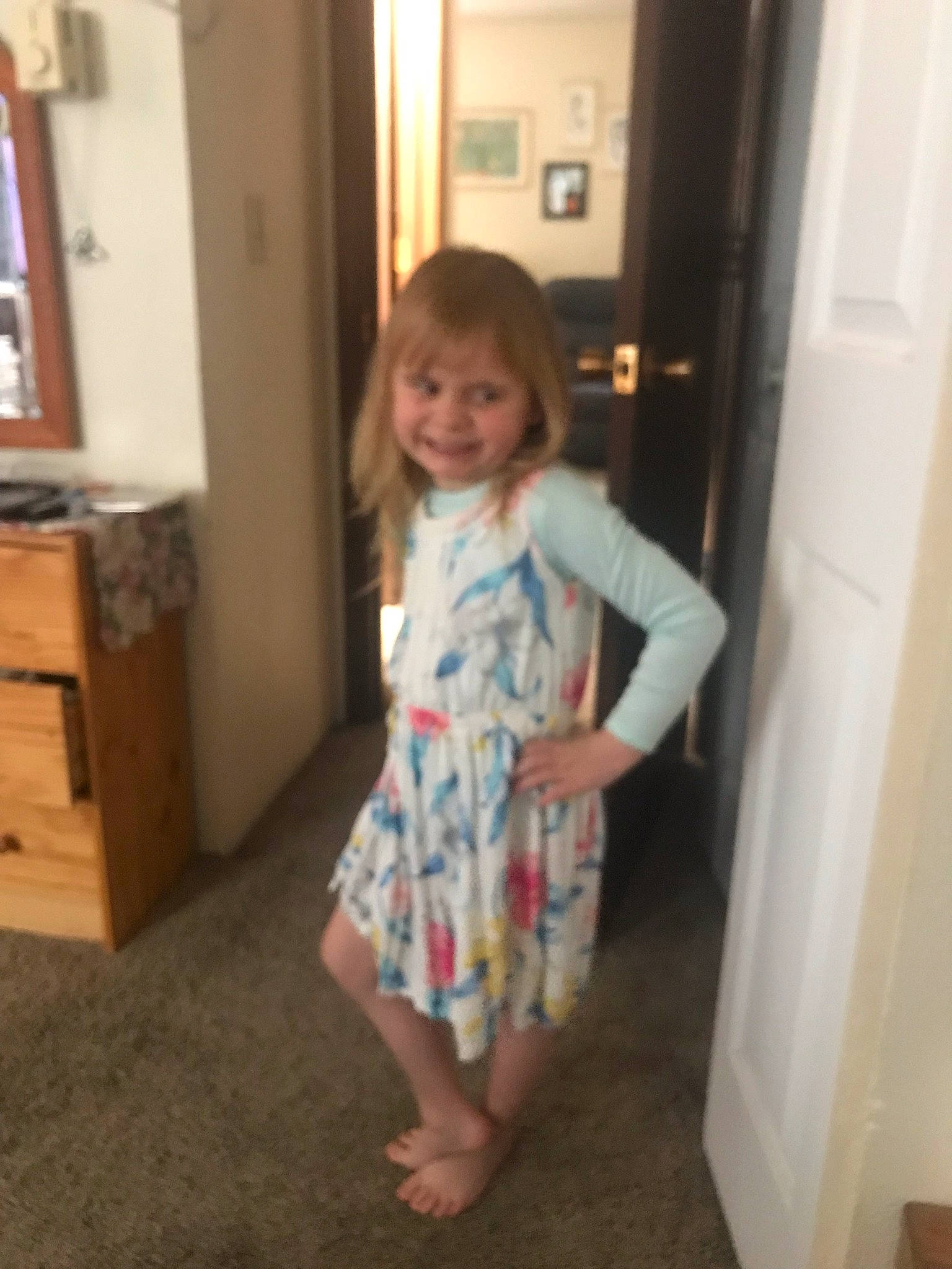 Melody is registered to the contest to win money with this photo: baby_toddler_clothing, barefoot, day_dress, door, drawer, dress, flooring, fun, hardwood, human_leg, joy, knee, one_piece_garment, person, sleeve, smile, standing, thumb, toddler, waist