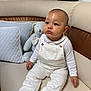 Liam a rejoint le concours — aidez-le/la à gagner de superbes lots ! baby, child, infant, white_overalls, socks, couch, leather, pillow, quilted_pillow, teddy_bear, plush_toy, indoor, seated, curious, face, head, person, furniture, cozy, cute