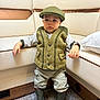 Liam participe au concours pour gagner de l'argent avec cette photo : child, boy, boots, vest, cap, indoor, carpet, furniture, sofa, curious, standing, clothing, portrait, expression, floor, room, casual, cute, toddler, person